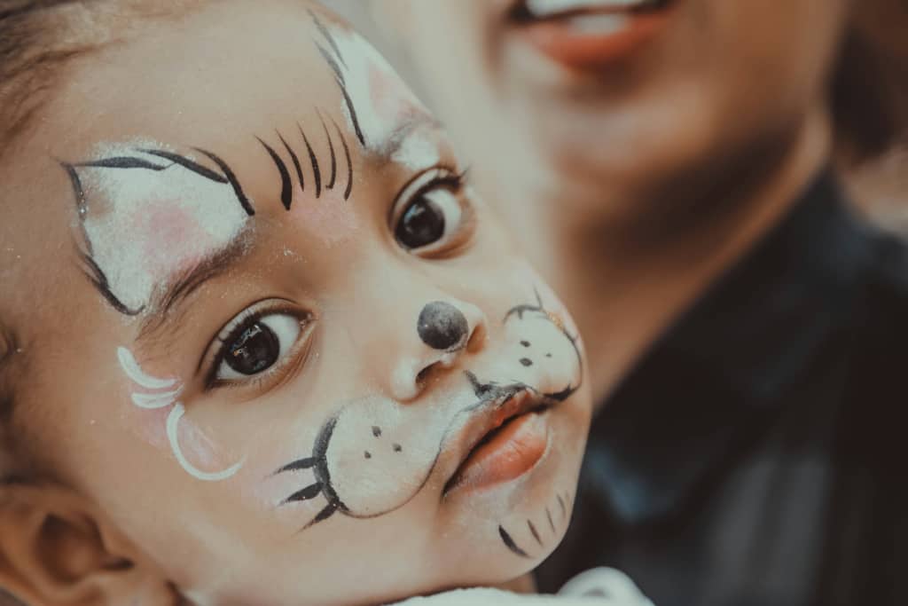 Baby with face paint for fall pumpkin patch