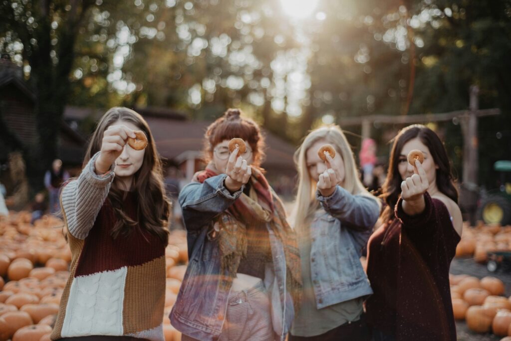 four ladies holding a small sized donuts