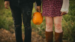 young couple holding a pumpkin in autumn setting